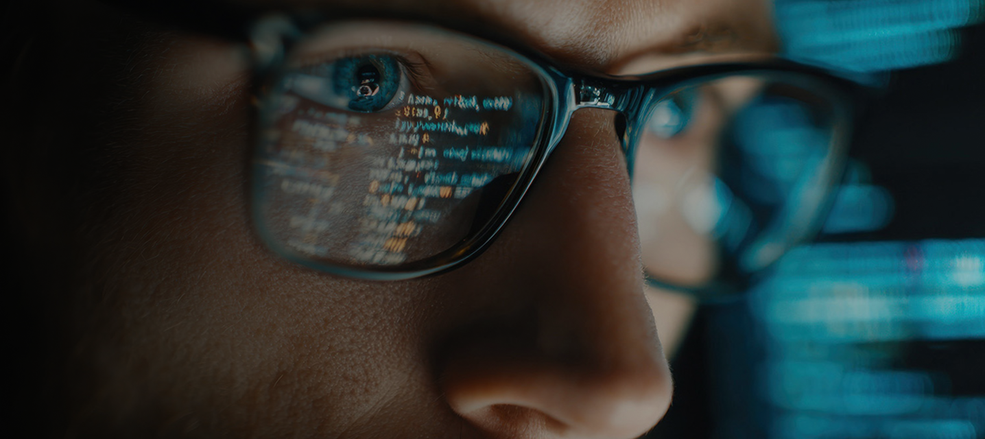 Reflejo de líneas de código en un lente durante un proceso de programación.